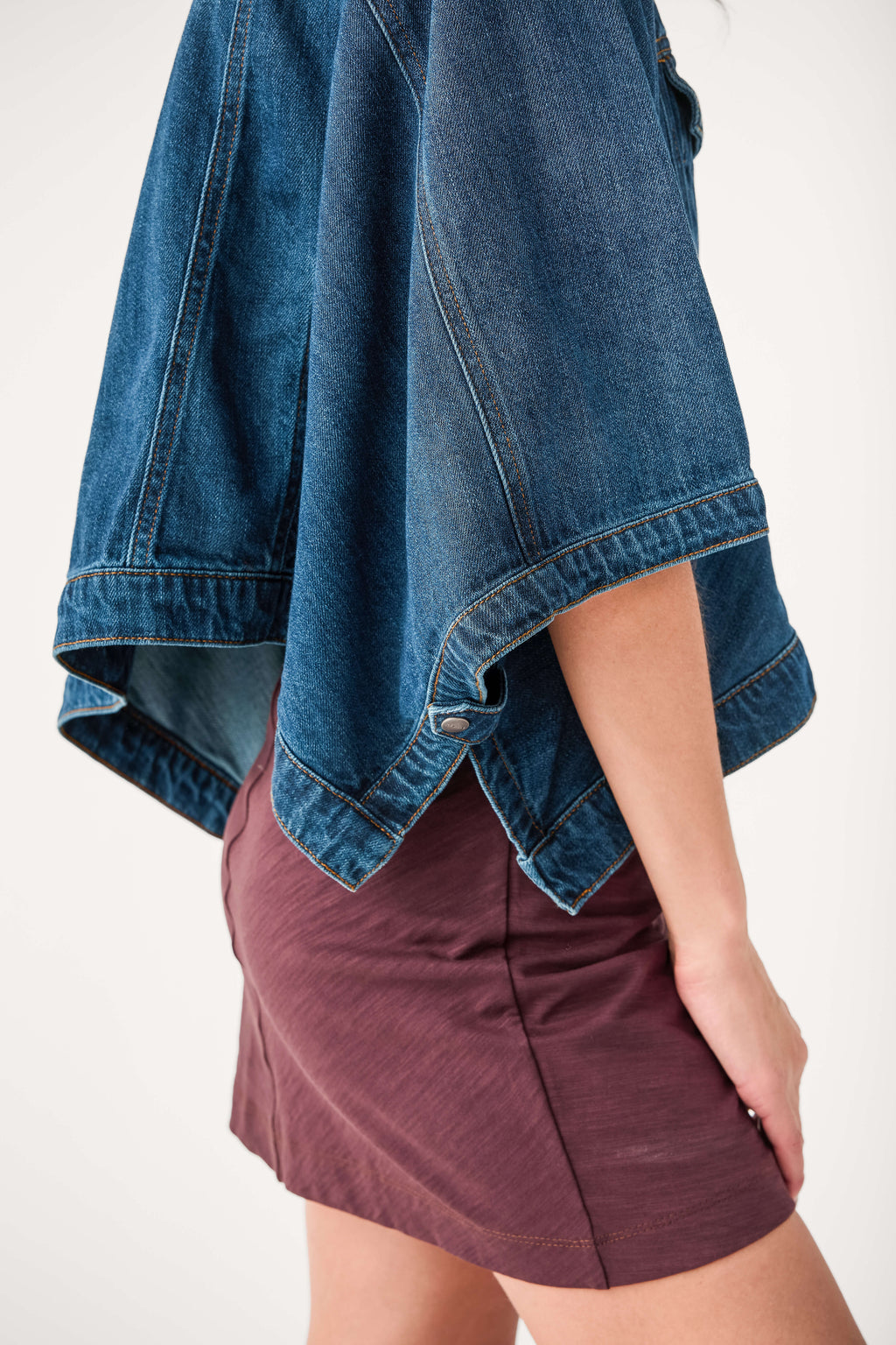 Cape-sleeve denim jacket hem detail, medium blue wash with draped raw edge