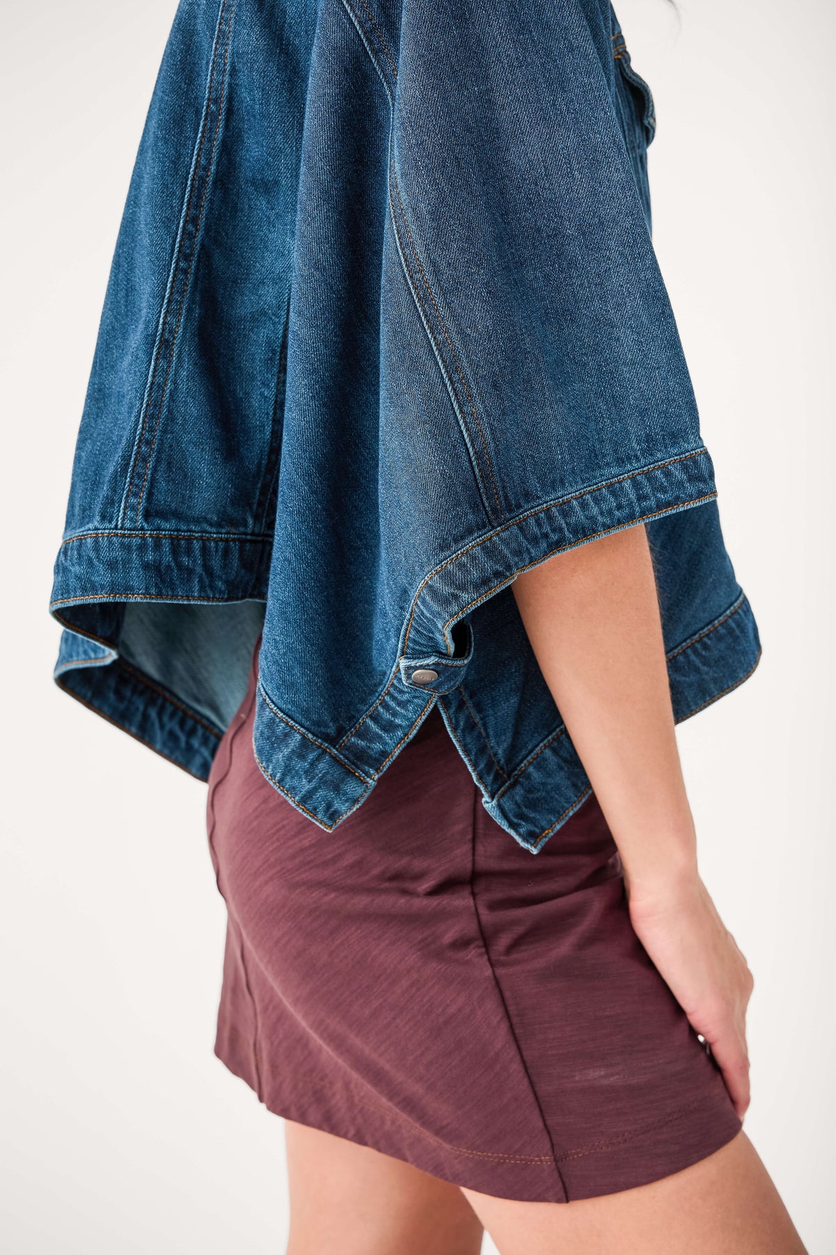 Cape-sleeve denim jacket hem detail, medium blue wash with draped raw edge