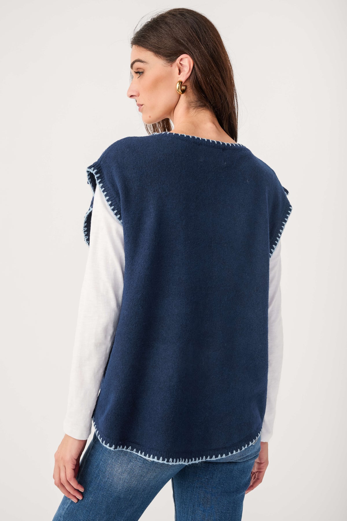 Back view of navy cap sleeve blanket-stitch sweater with contrast white sleeves