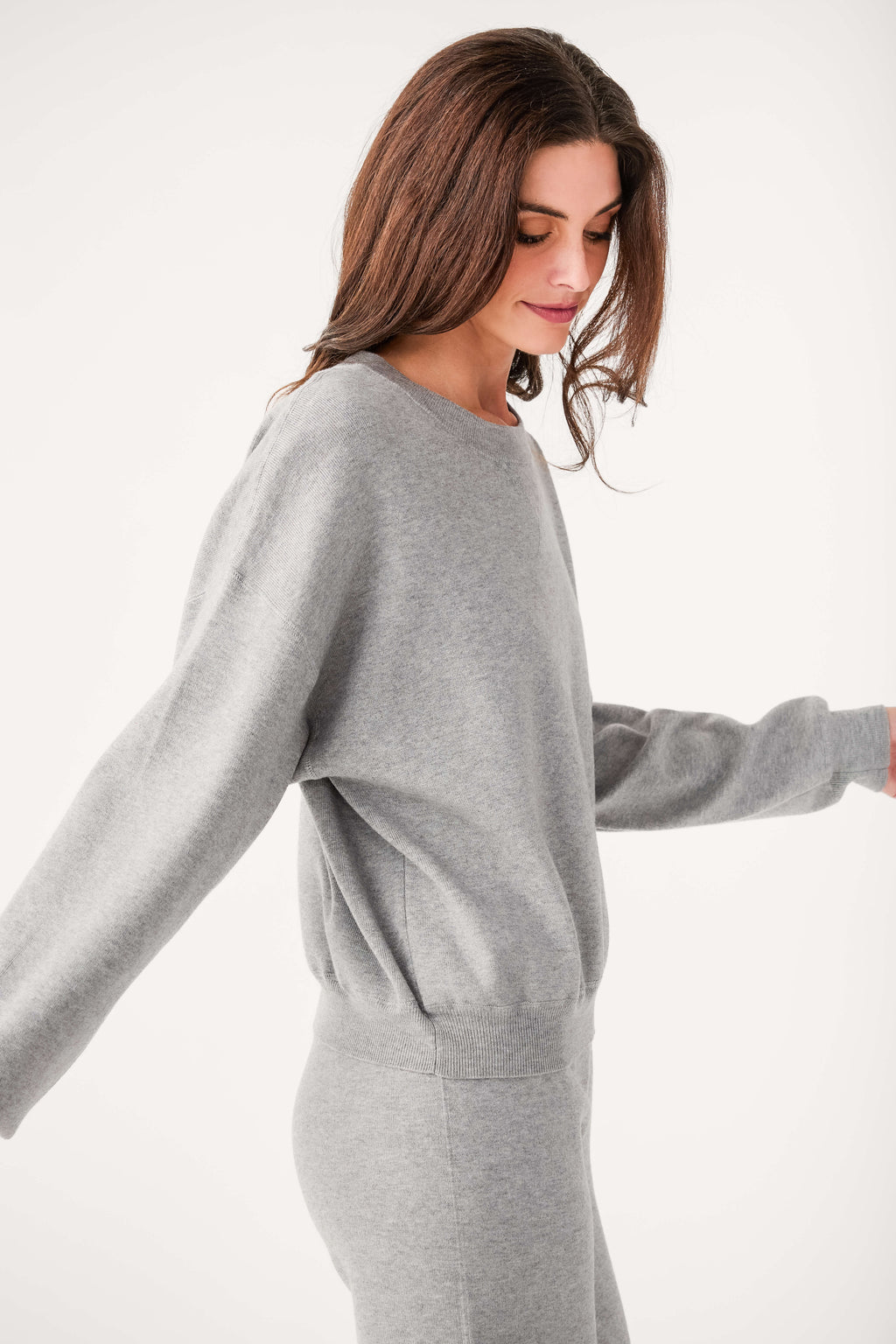Relaxed crewneck sweater in heather gray, side view with ribbed waist hem
