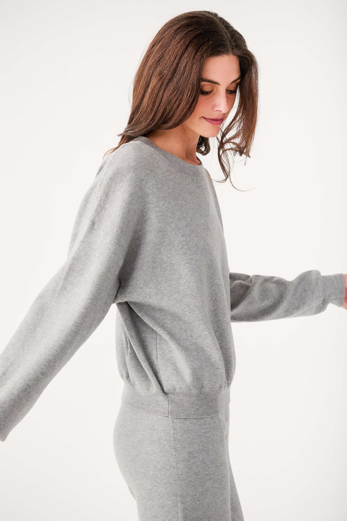 Relaxed crewneck sweater in heather gray, side view with ribbed waist hem