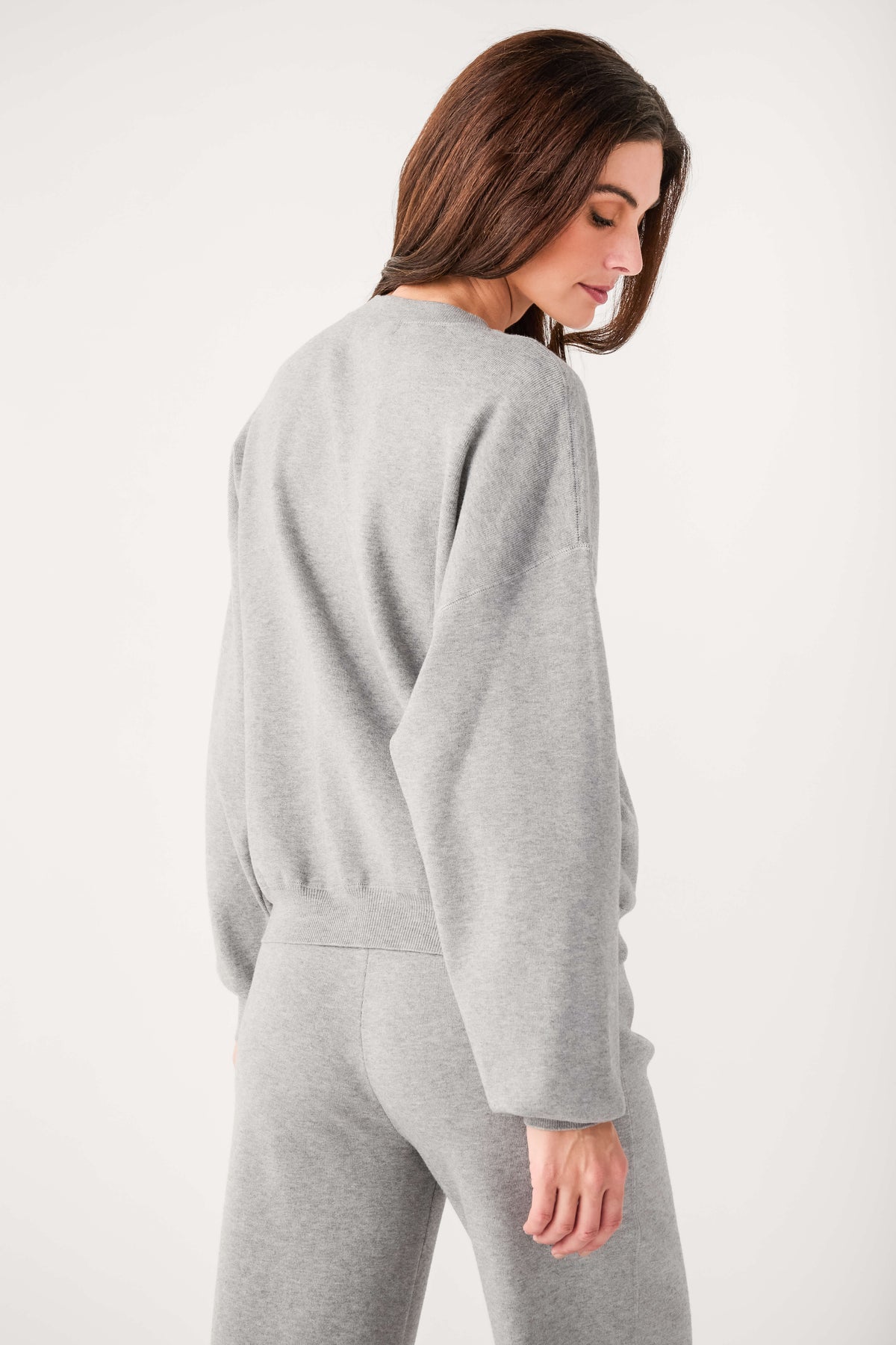 Relaxed crewneck sweater back view in heather gray with ribbed waist hem