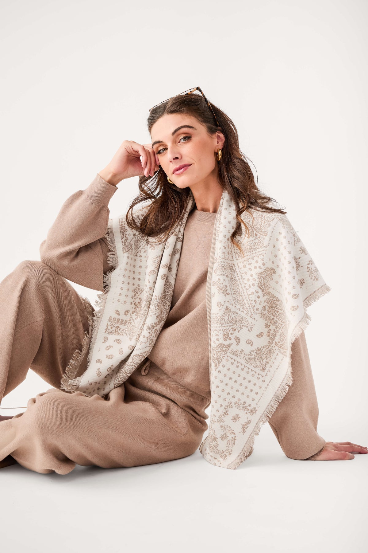 Ivory bandana-print scarf with fringed edges, draped around shoulders