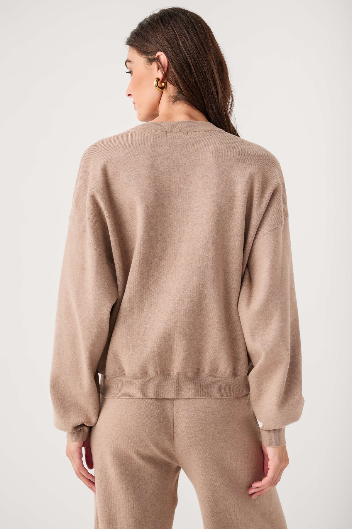 Relaxed crewneck sweater back view in heather taupe with ribbed waist hem