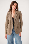 Brown check blazer with notch lapels and flap pockets, worn over jeans