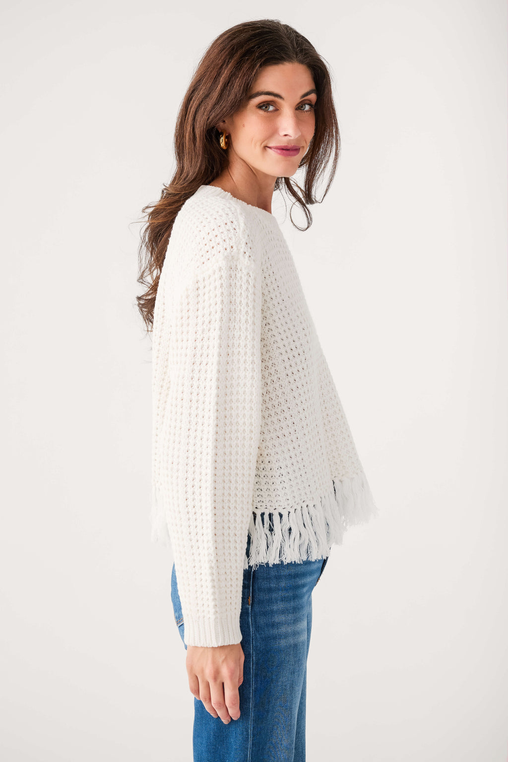 White textured knit crewneck sweater, long sleeves and side view with fringe hem