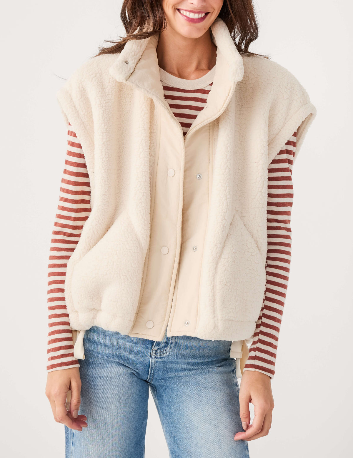 Cream sherpa-style fleece vest with snap button front and stand collar, front view.