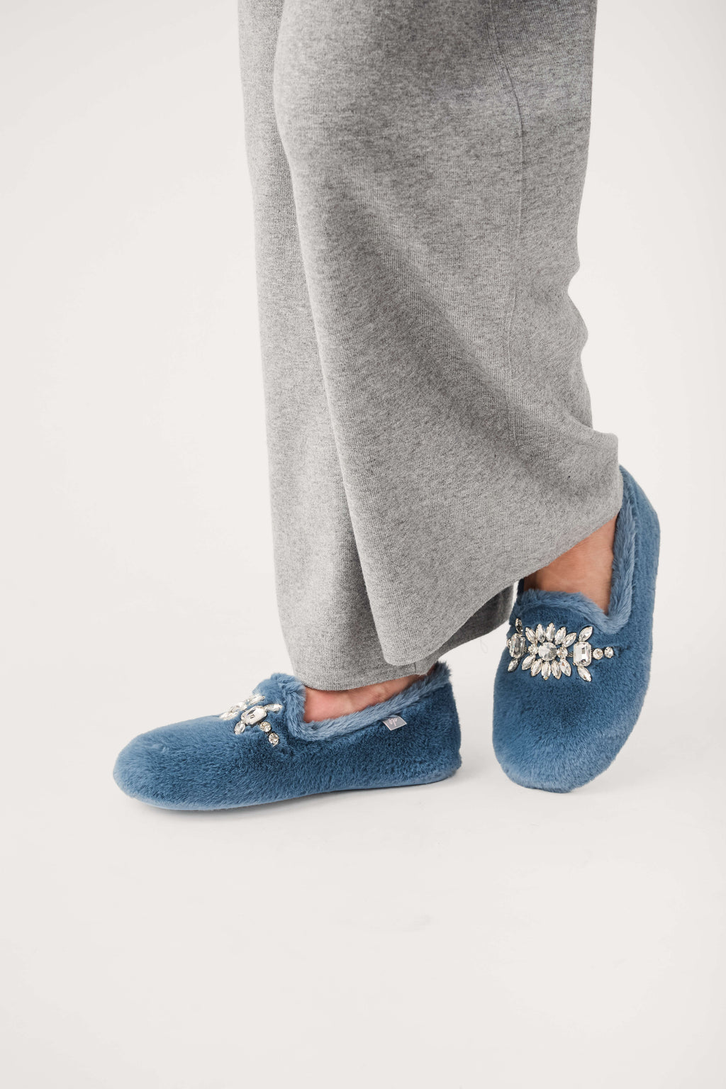 Blue fuzzy loafer slippers with jeweled floral embellishment and slip-on design