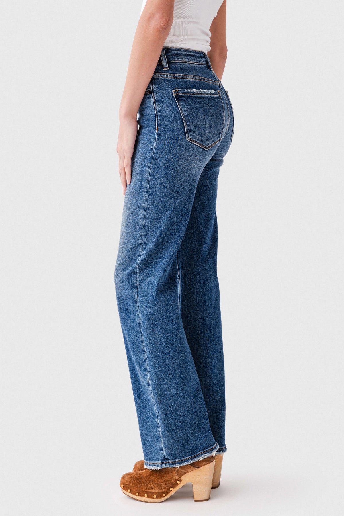Women's dark wash high-rise straight-leg jeans, side view with cuffed hem and seam details