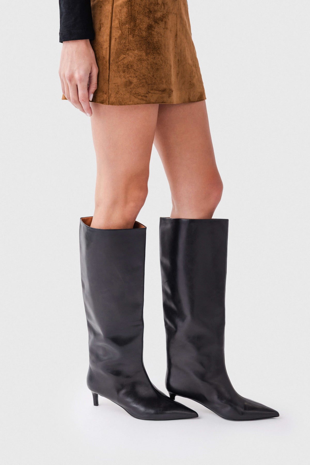Black leather knee-high boots with smooth finish and slim kitten heels.