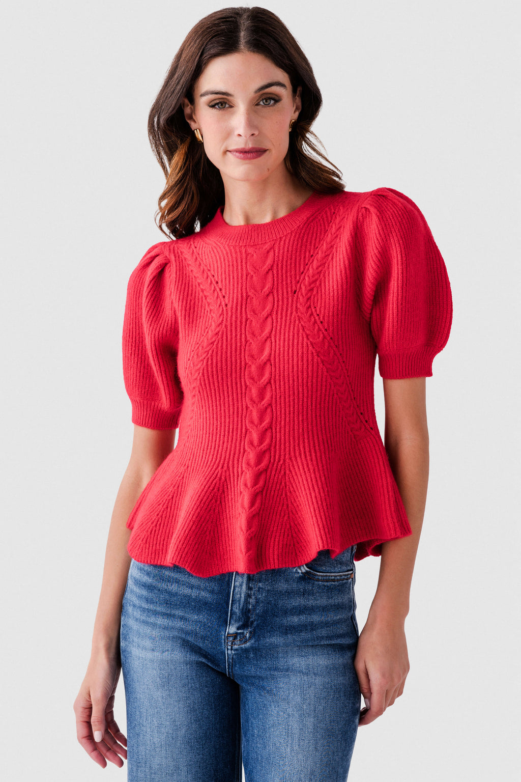 Red textured knit peplum top with puff sleeves and cable pattern front detail.