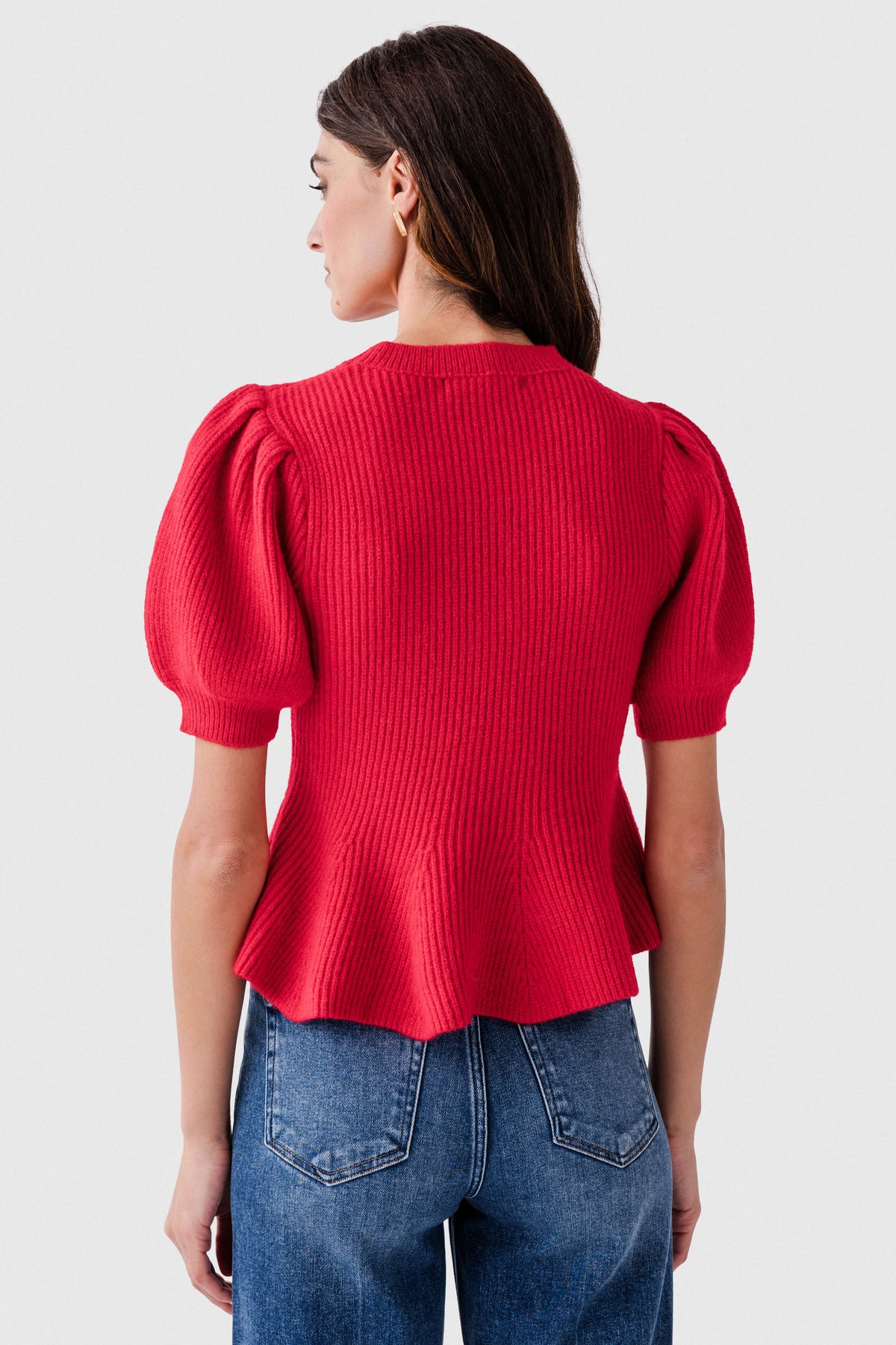 Red knit peplum top, back view with gathered puff sleeves and ribbed knit texture.