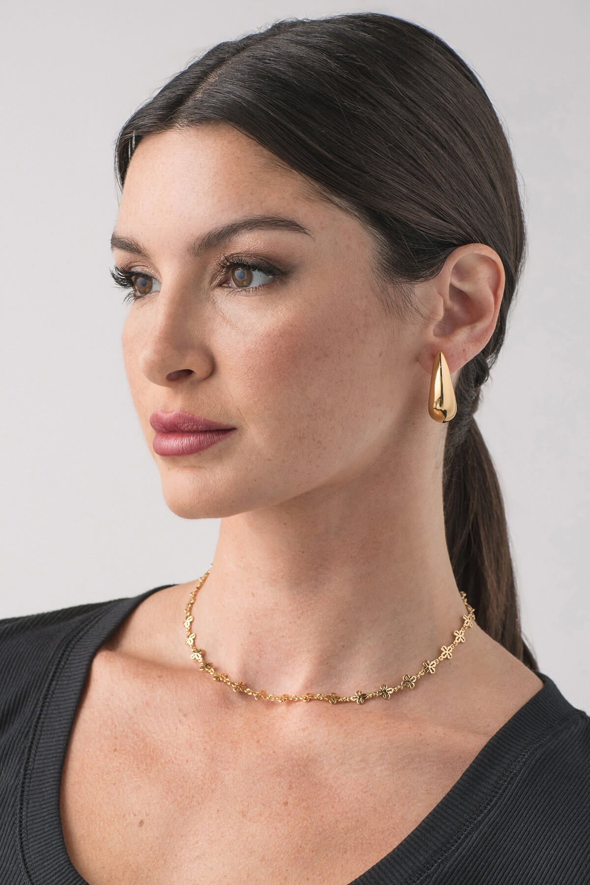 Gold crescent hoop earrings with visible post backs on model