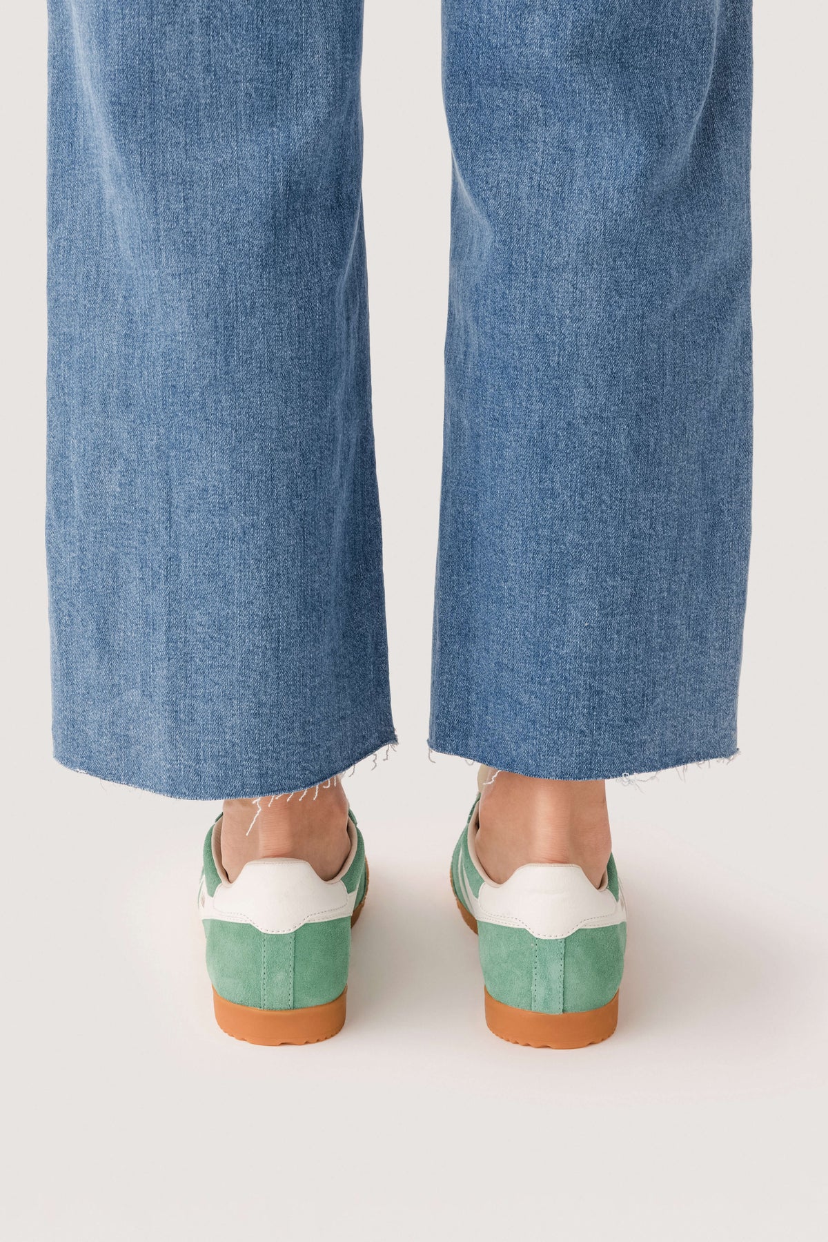 Pair of green low-top sneakers with white accents and tan rubber heels
