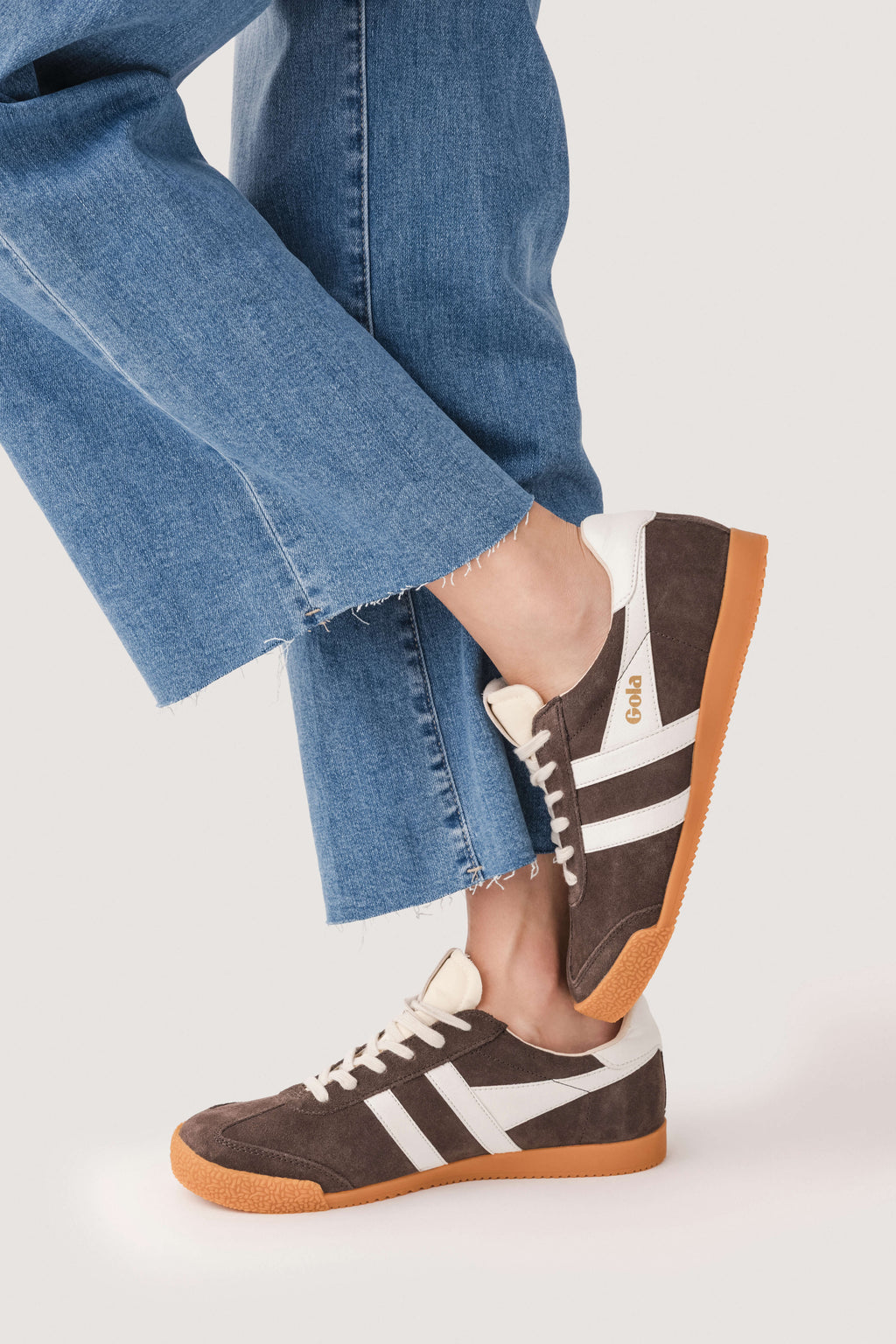 Brown low-top sneakers with white stripes and gum sole, front and side view.