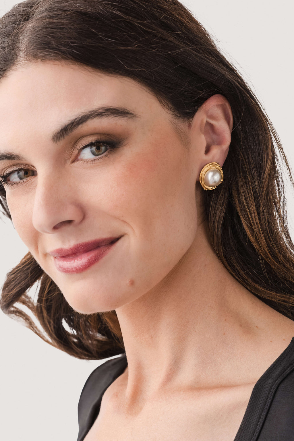 Gold-tone hoop earrings with round pearl, shown on model's ear