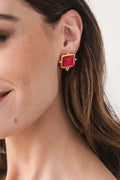 Gold square red glass stud earrings, side view on pierced ear