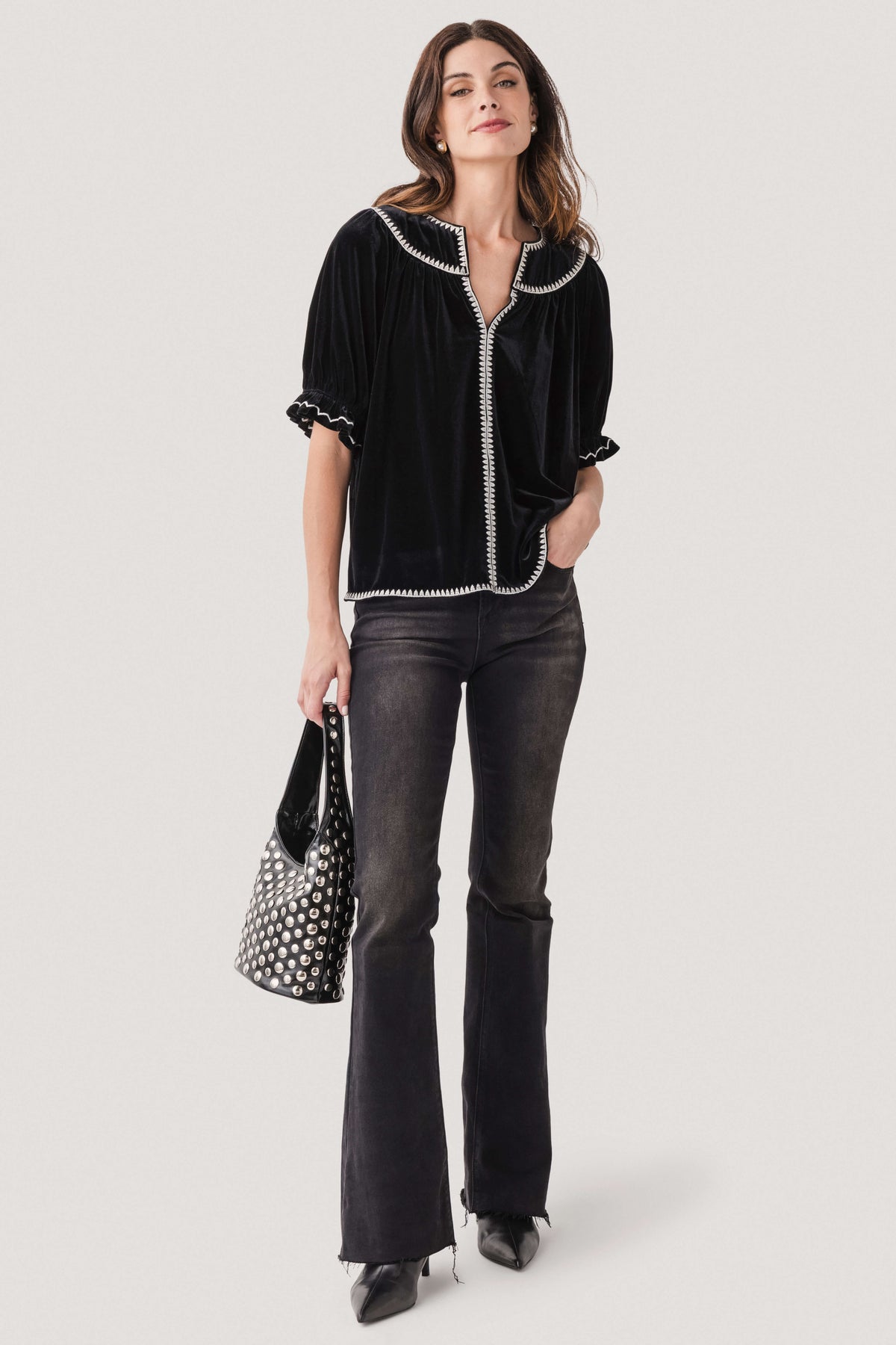Black studded handbag with silver-tone metal studs and short top handles