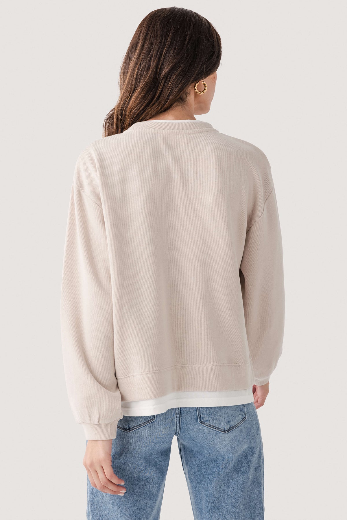 Light beige crewneck pullover sweater shown from the back with long sleeves