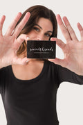 Gift card in front of face; black card with white printed logo