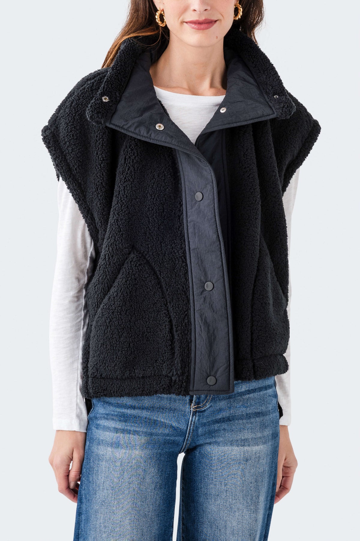 Black fleece vest with full front zipper, stand collar, and snap pockets