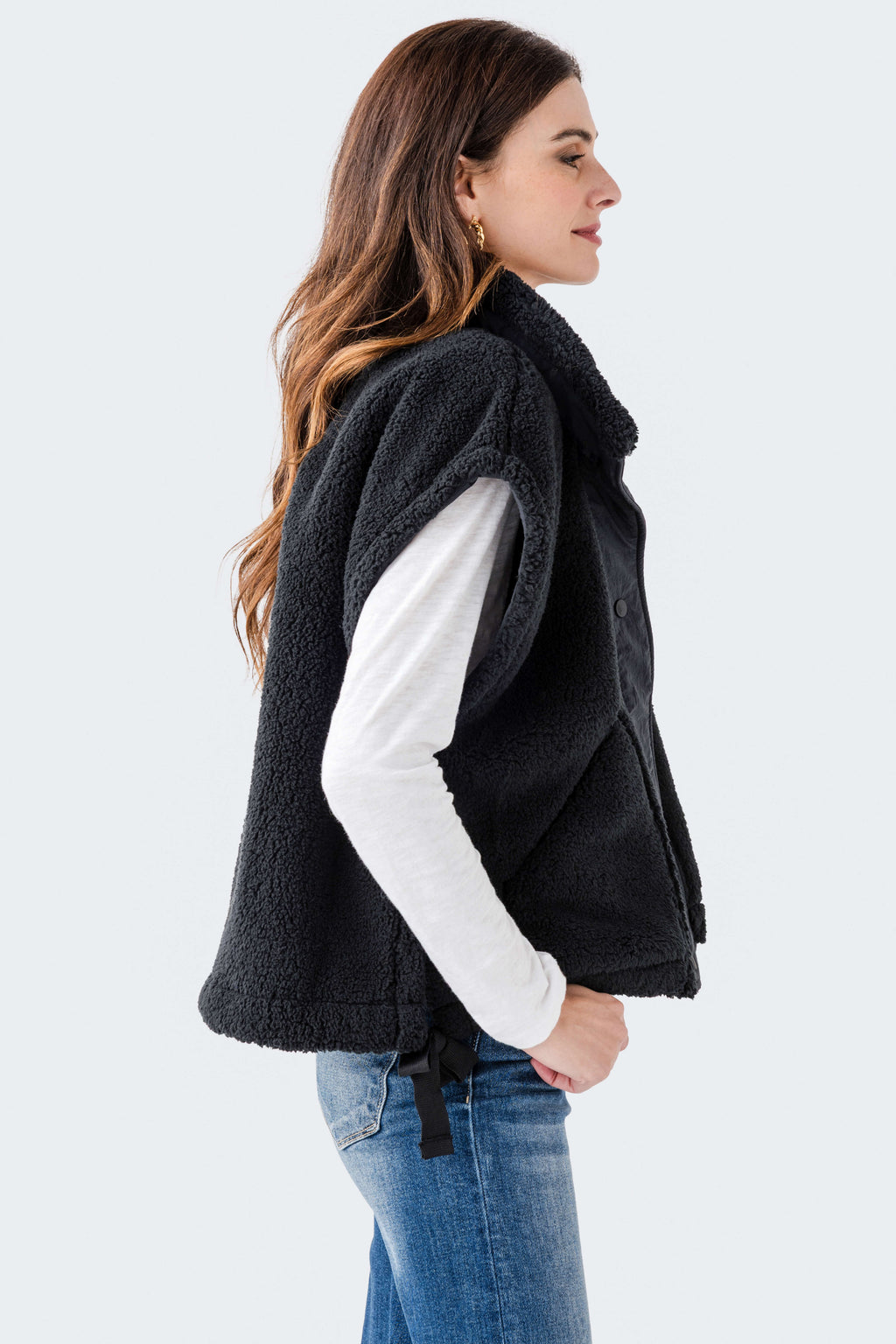 Black sherpa fleece vest with high collar and sleeveless quilted silhouette