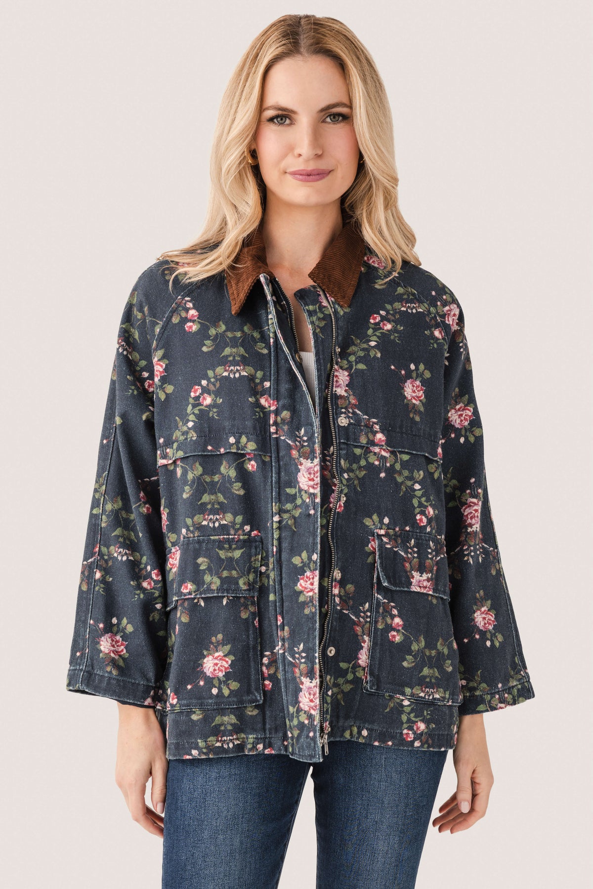 Floral printed utility jacket with zip front and flap pockets, dark navy floral pattern detail.