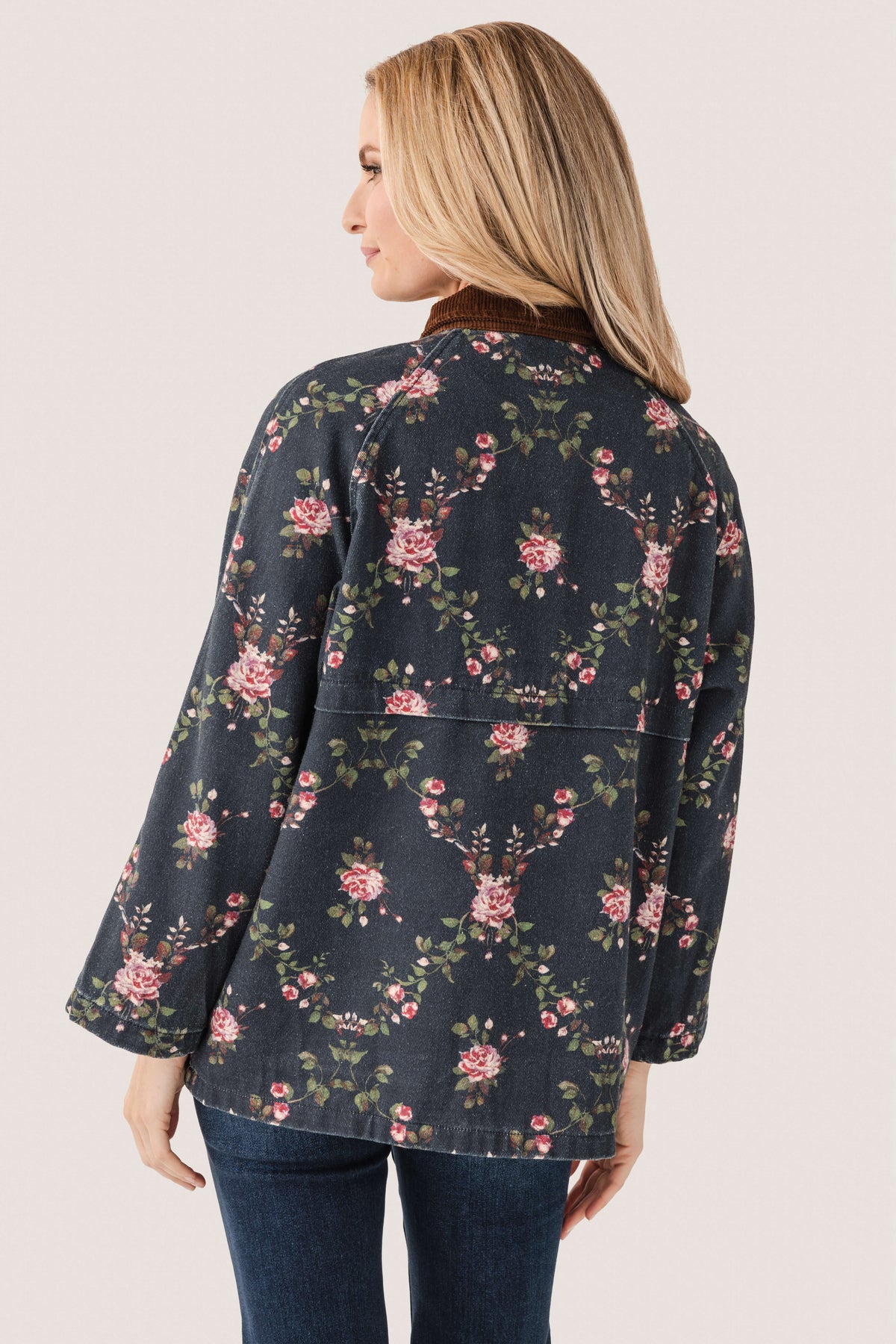 Back view of floral printed utility jacket with full zipper, dark navy floral pattern.