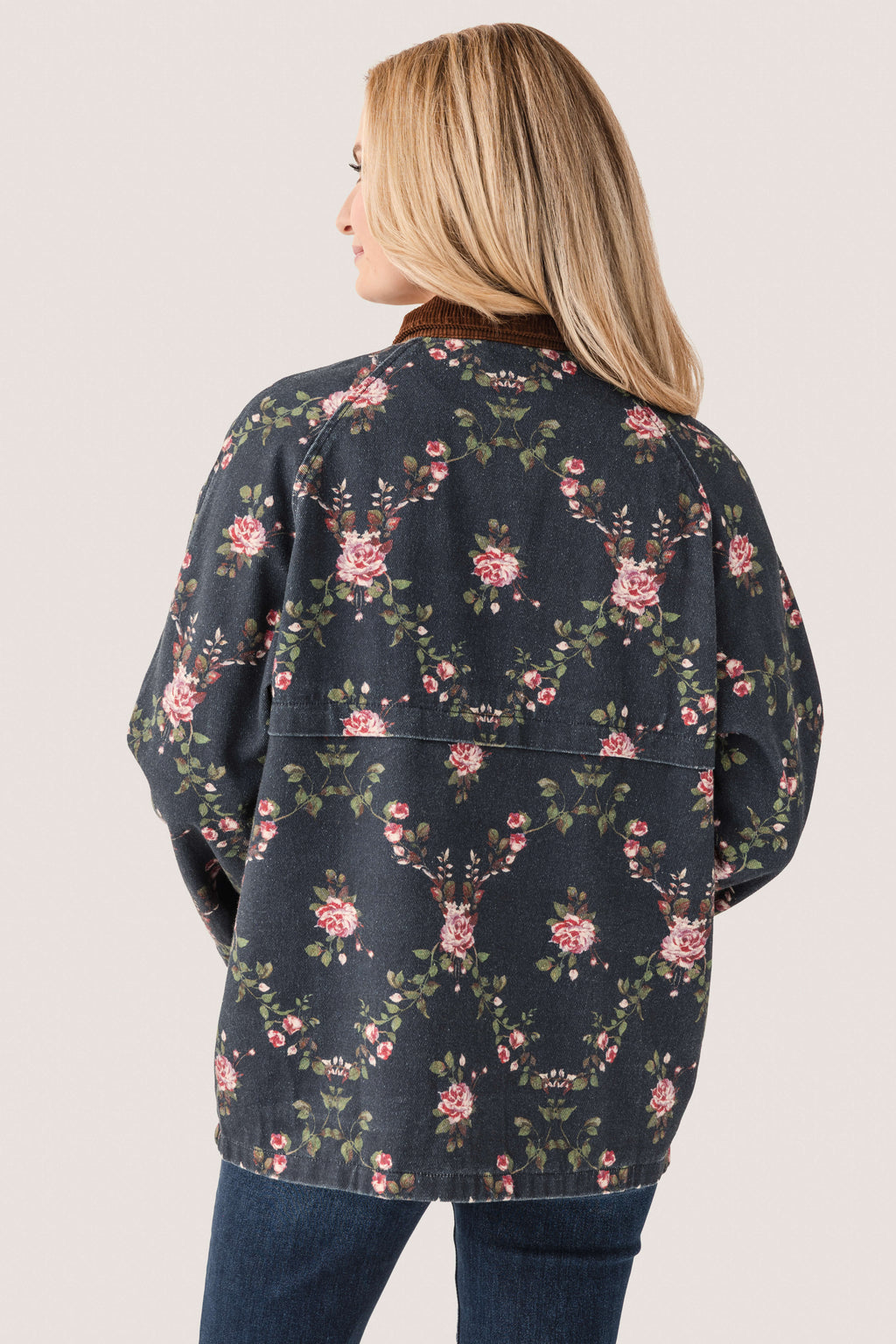 Back view of dark navy floral utility jacket with full zipper, long sleeves, and pockets.