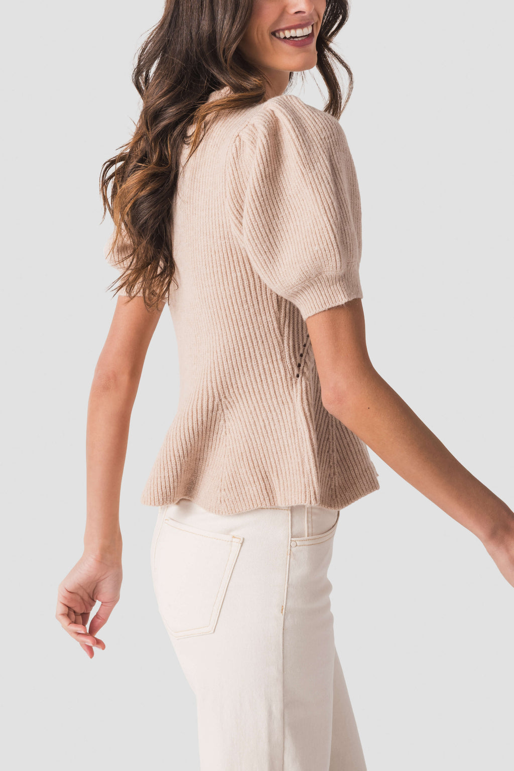 Oatmeal knit top with puff sleeves and flared hem, side view
