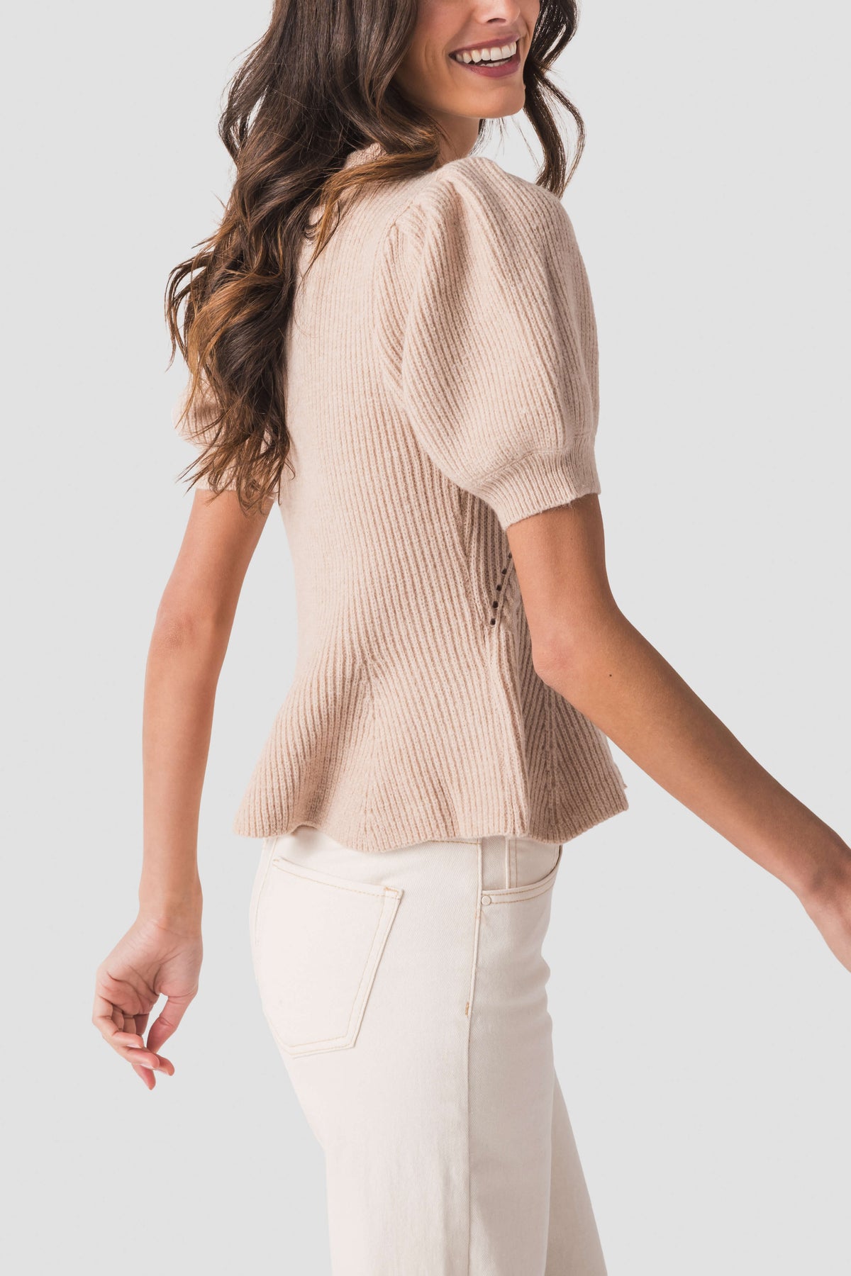 Oatmeal knit top with puff sleeves and flared hem, side view