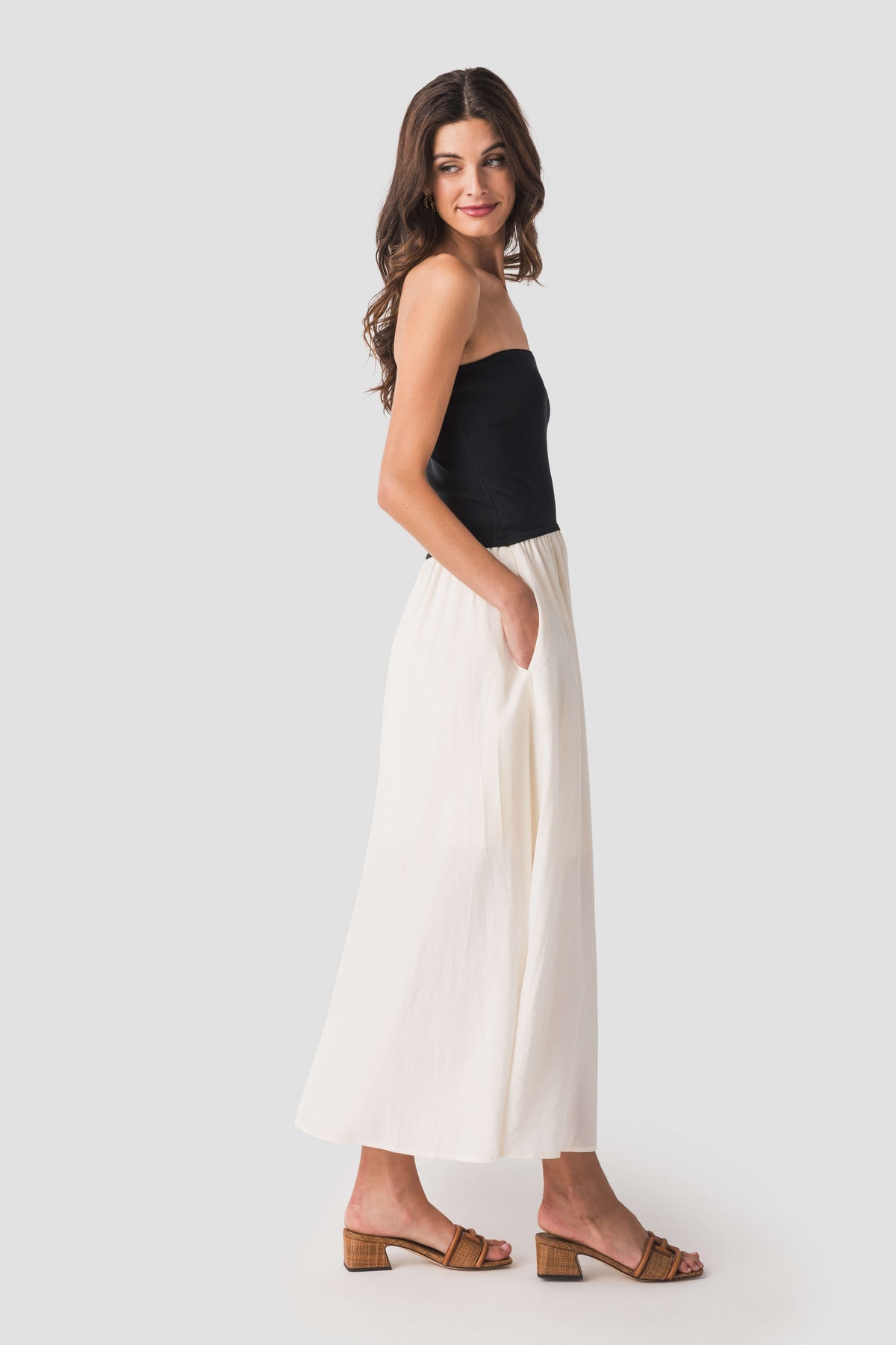 Side view: two-tone strapless midi dress with black bodice and cream skirt
