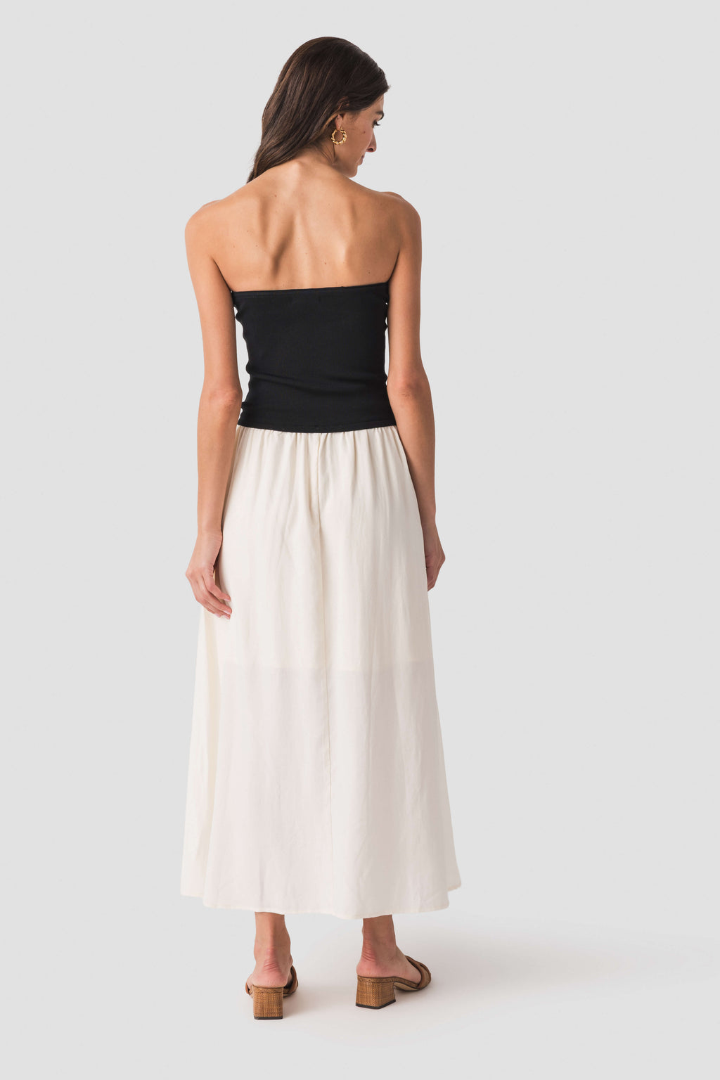 Back view: strapless two-tone midi dress with black bodice and cream skirt