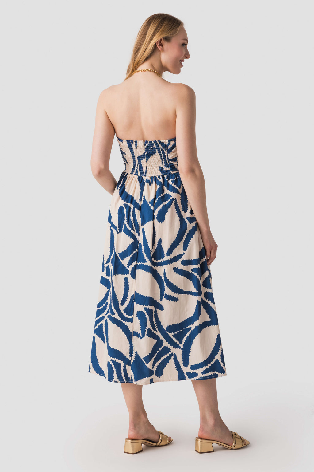Back view of blue-and-white strapless midi dress with abstract pattern and ruched waistband