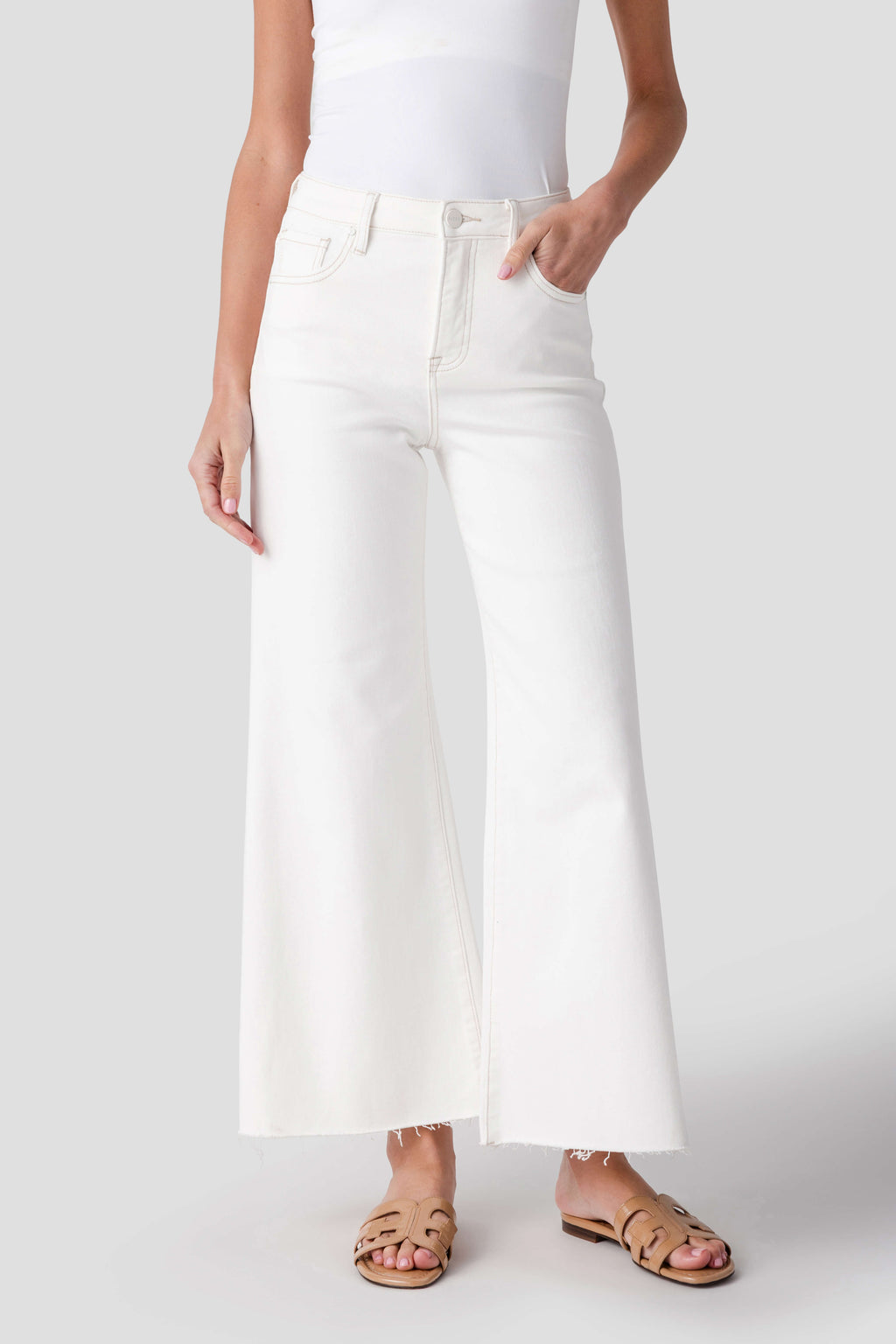 Cream palazzo pants with side seams, front pockets, and raw-cut hem edge
