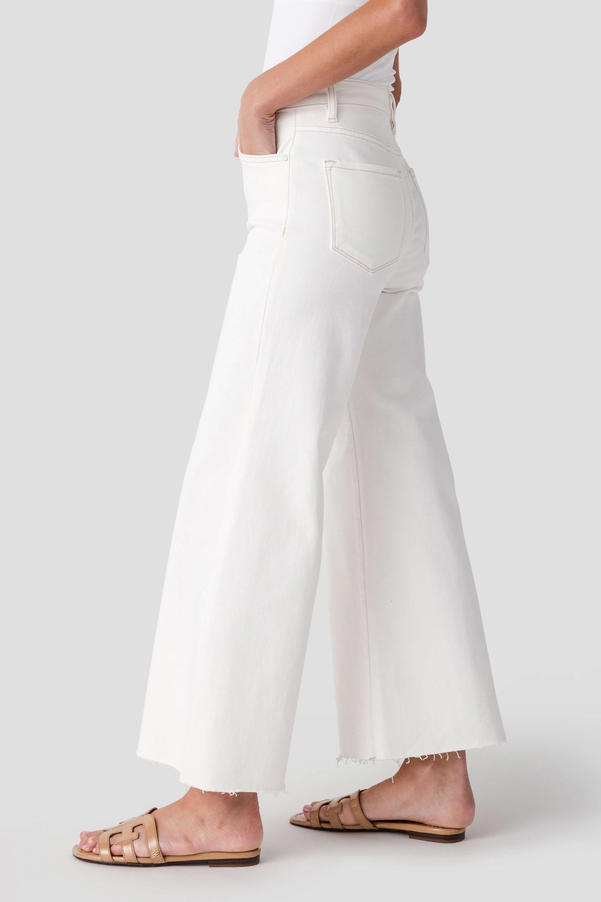 Cream cropped palazzo pants with raw hem and relaxed wide-leg shape