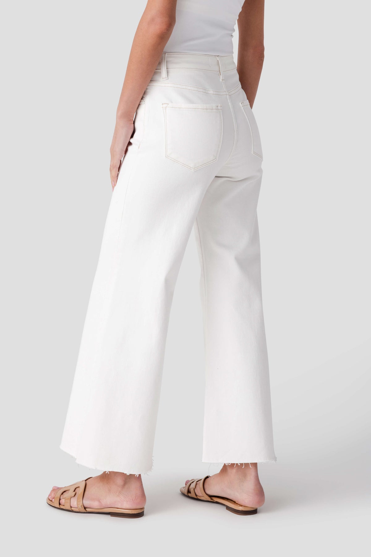 Cream wide-leg palazzo pants with raw hem, front pockets, and belt loops