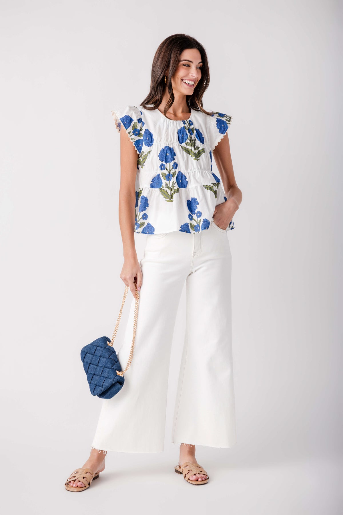 White tiered blouse with blue floral print and ruffled cap sleeves