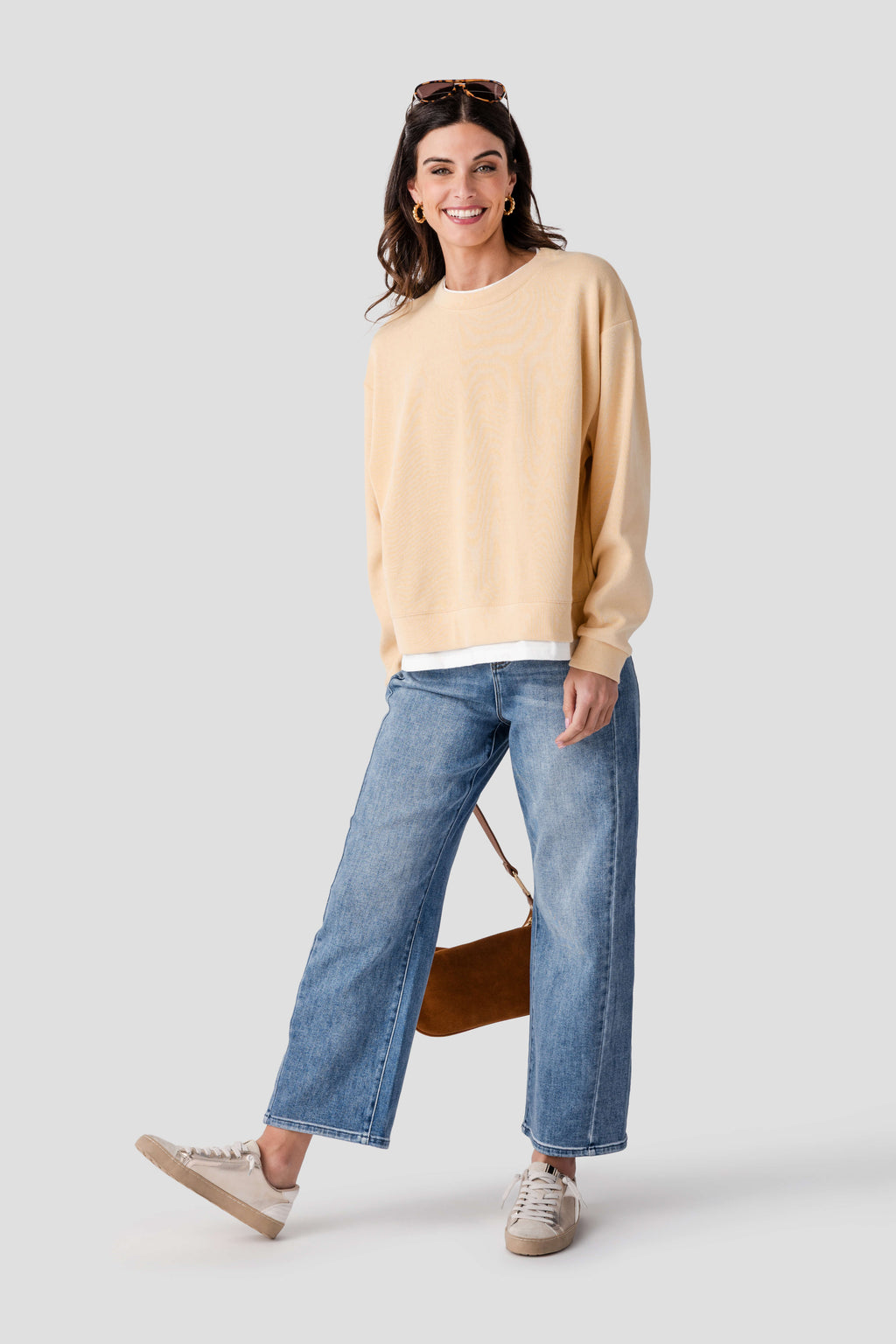 Light beige crewneck pullover with ribbed cuffs and hem, white trim along the bottom