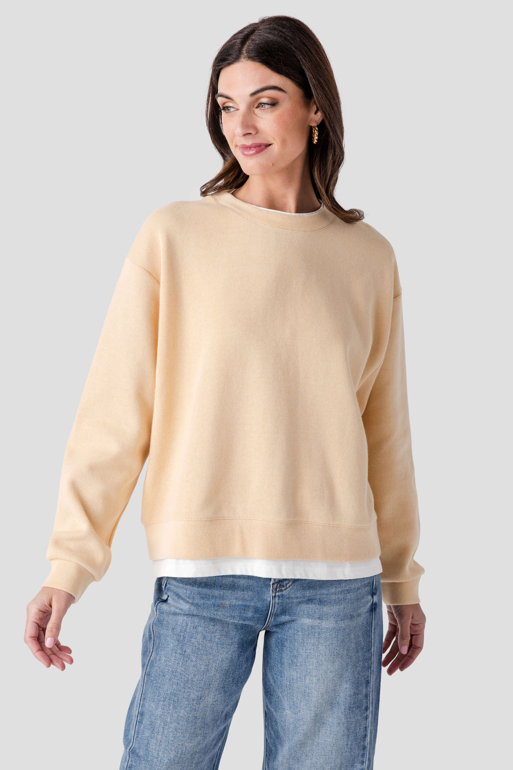 Light tan crewneck pullover with ribbed collar, cuffs, and hem