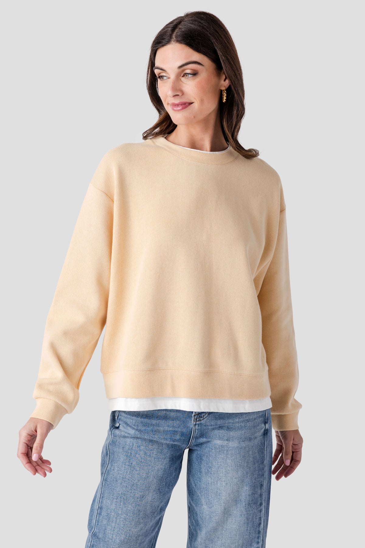 Light tan crewneck pullover with ribbed collar, cuffs, and hem