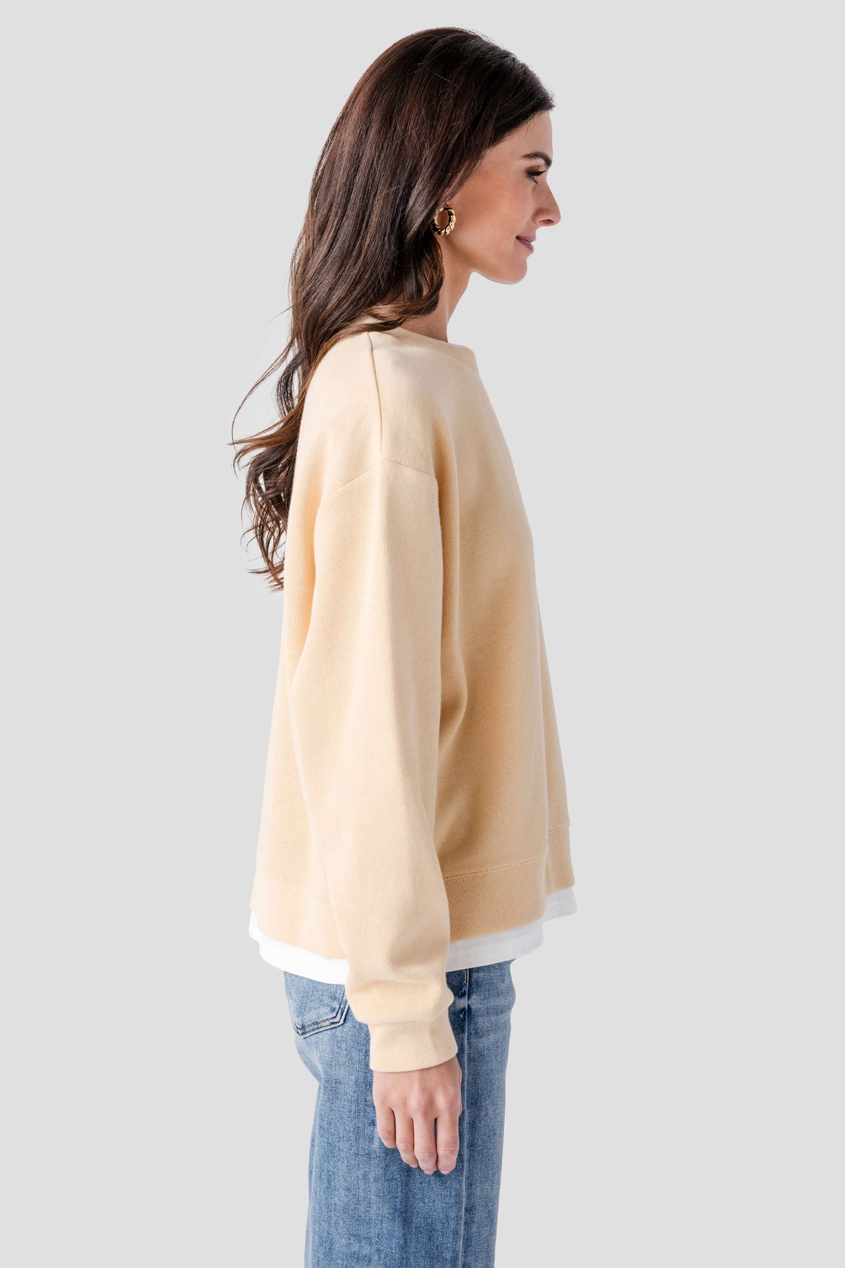Back view of light beige crewneck pullover with ribbed cuffs and hem, white trim