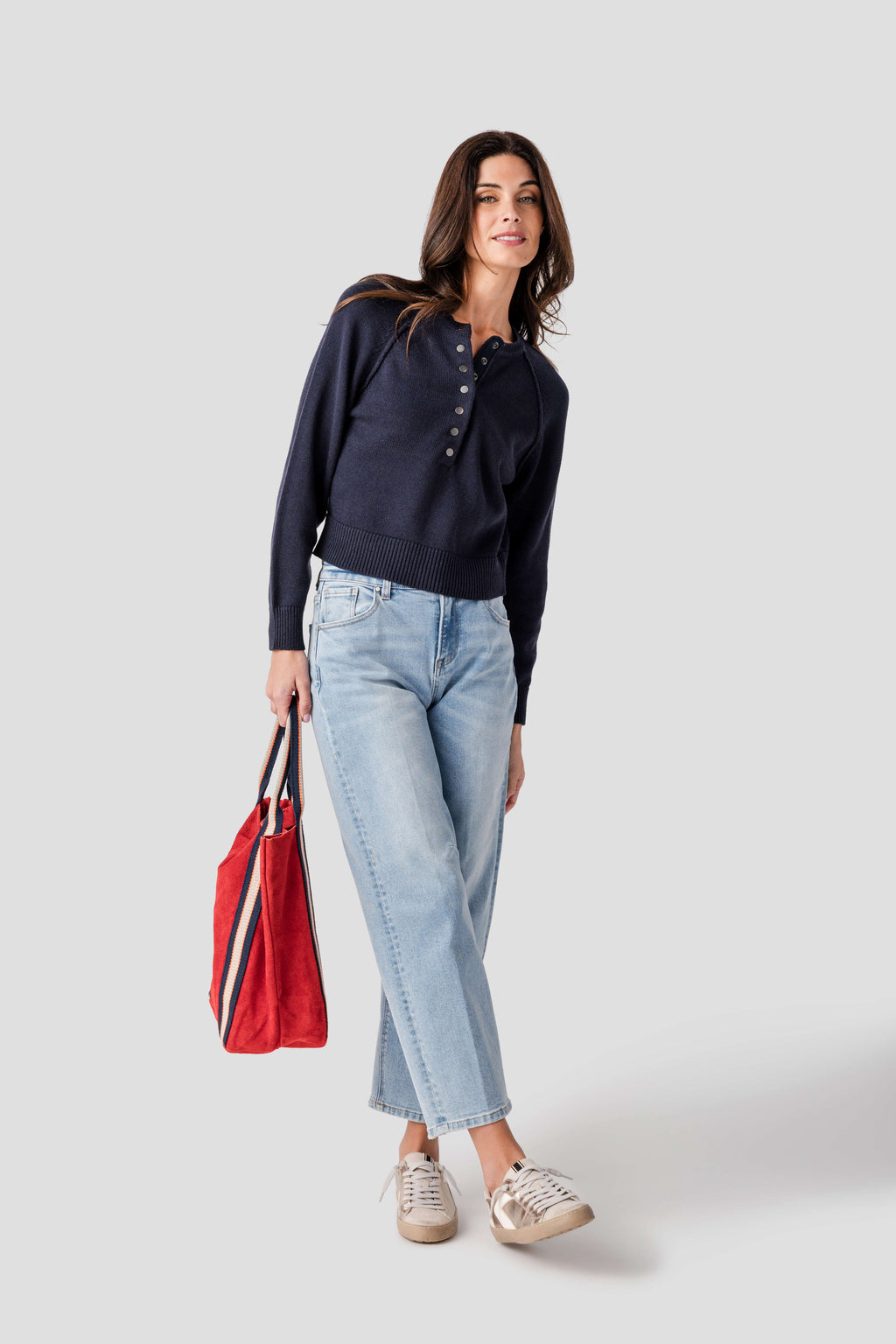 Women’s medium wash barrel jeans with relaxed leg opening, ankle length, worn with shoes.