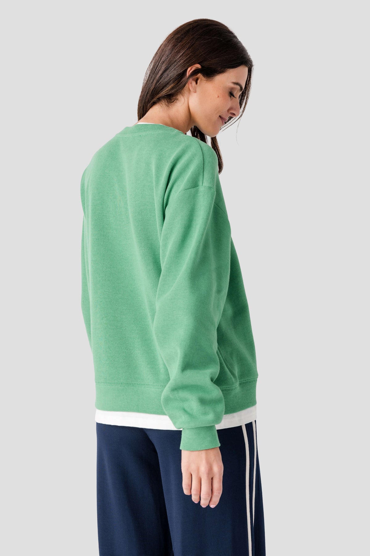 Green crewneck pullover with long sleeves and ribbed cuffs and hem, back view