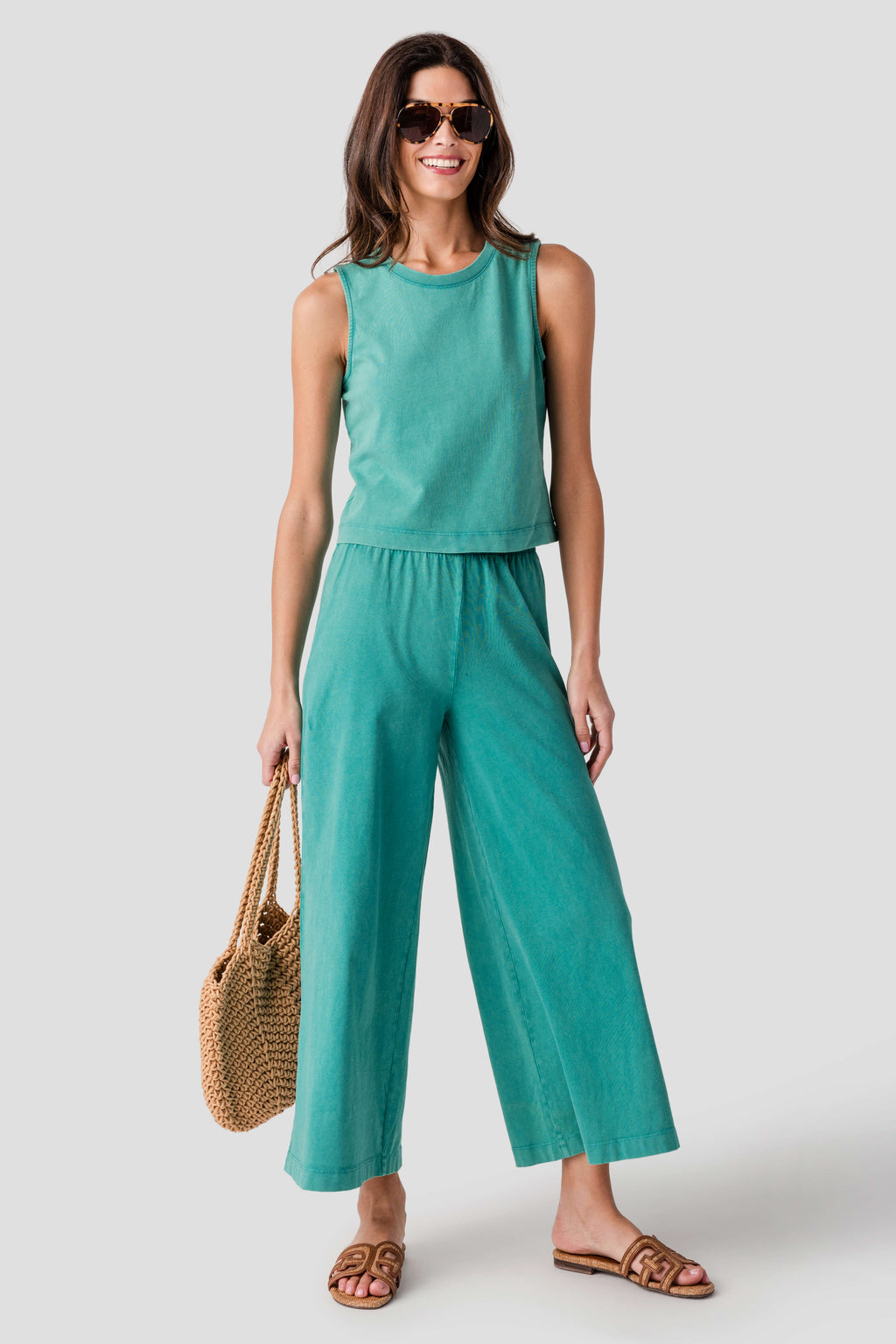 Teal sleeveless muscle tank with crew neck, gathered waist, and flowy wide-leg pants.