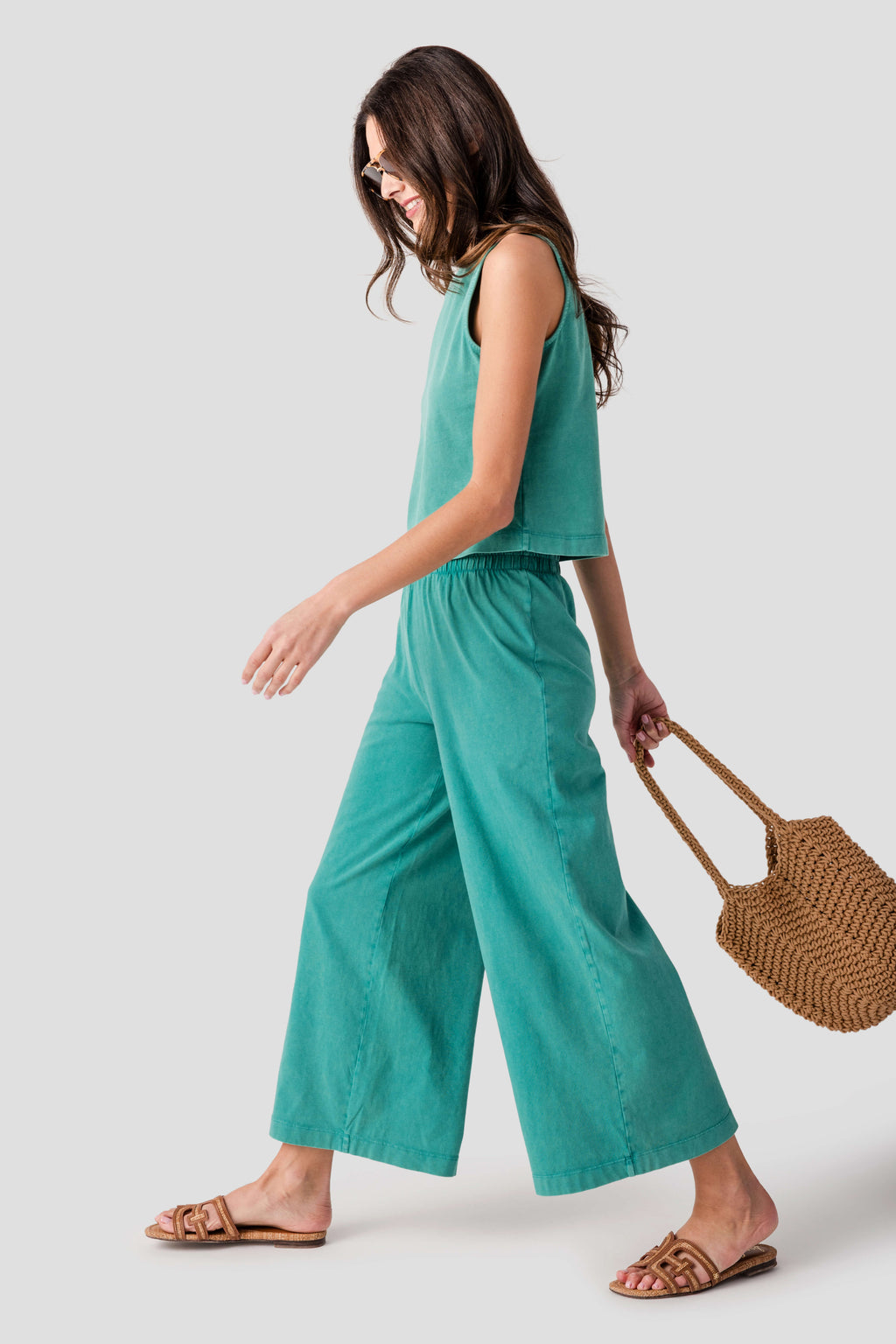 Teal jersey crop flare pants, elastic waistband and wide cropped legs, side view