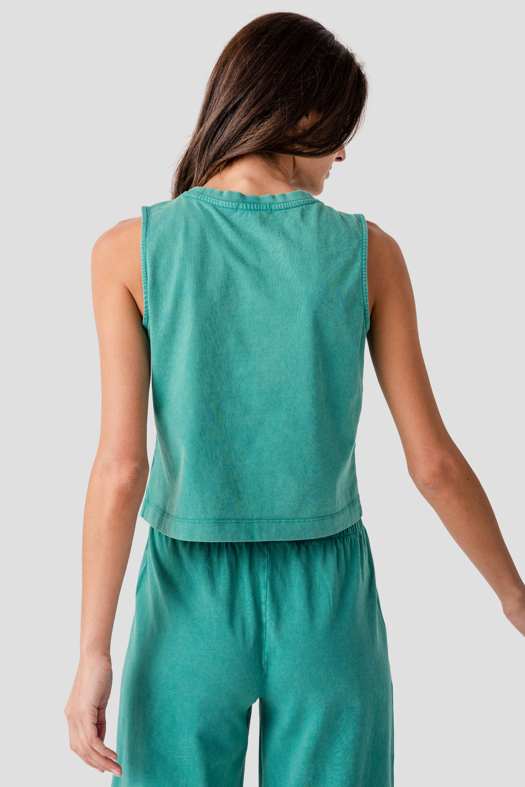 Back view of teal sleeveless jersey muscle tank with gathered waist and tiered hem.