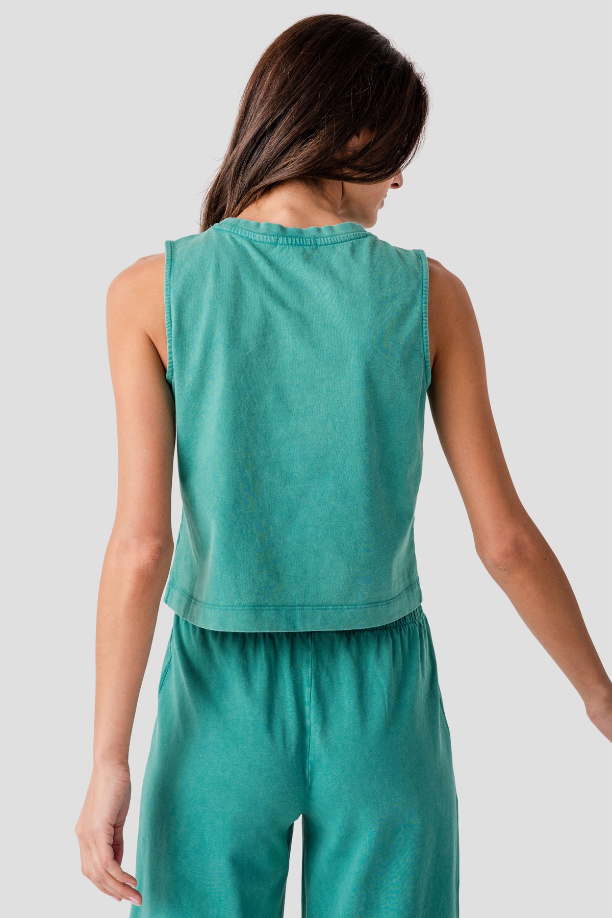 Back view of teal sleeveless jersey muscle tank with gathered waist and tiered hem.