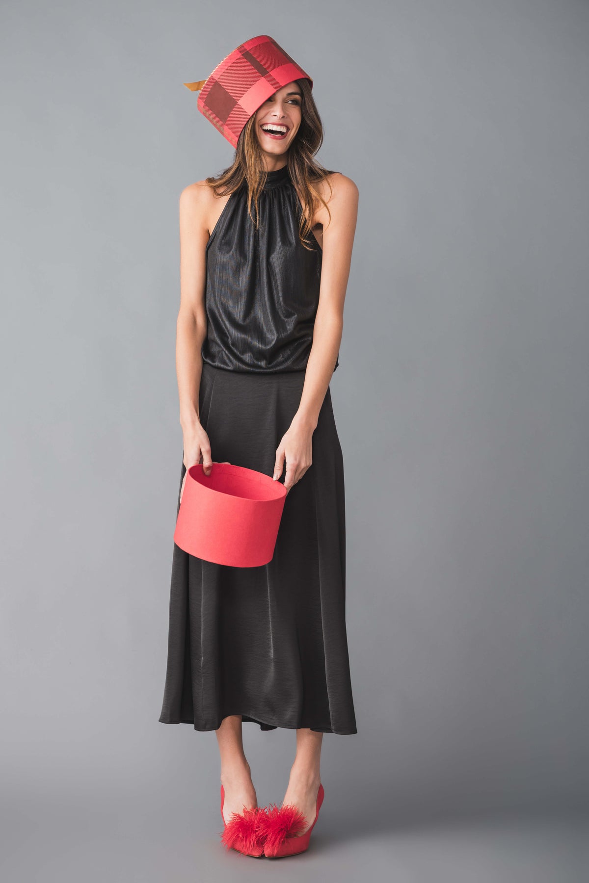 Black sleeveless halter tie-neck top with gathered neckline and silky sheen
