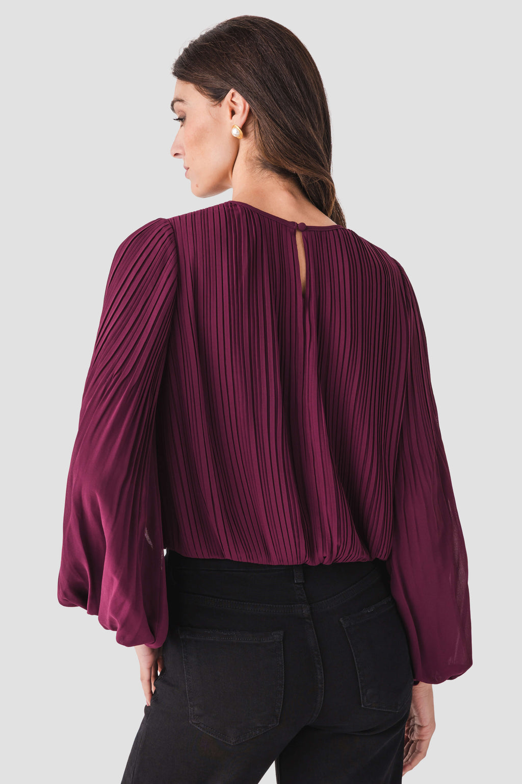 Back view of wine bubble hem top with vertical pleats and long puff sleeves